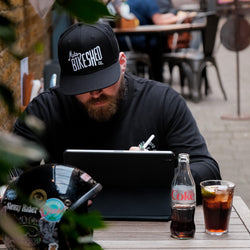 A black snapback baseball hat with 'Bike Shed Moto Co.' logo embroidered on the front.
