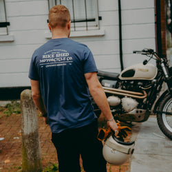 A navy-colored T-shirt with 'BIKE SHED MOTORCYCLE CO. COMMON GROUND' printed on the back.