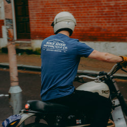 A navy-colored T-shirt with 'BIKE SHED MOTORCYCLE CO. COMMON GROUND' printed on the back.