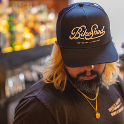 Bar staff member wearing our BSMC Motorcycle Garage Baseball Hat - Navy/White