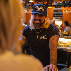 Bar staff member wearing BSMC Motorcycle Garage Baseball Hat - Navy/White