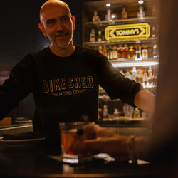 Bar staff member chatting while wearing our BSMC Deco Motorcycle Sweatshirt - Black/Gold