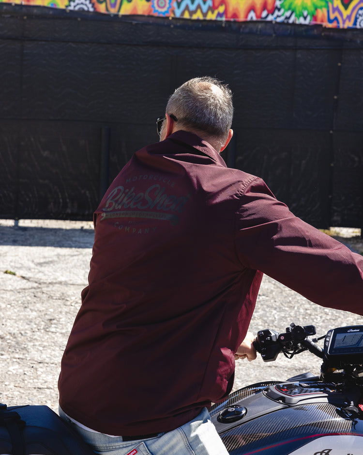 Dan sitting on his Indian bike while wearing our BSMC Company Coach Jacket - Burgundy 