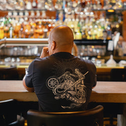 Bike Shed patron sitting at the bar wearing our BSMC Dragon Slayer T Shirt - Black
