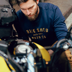 Alen inspecting his bike wearing our BSMC Moto Co. logo Sweatshirt - Navy/Mustard