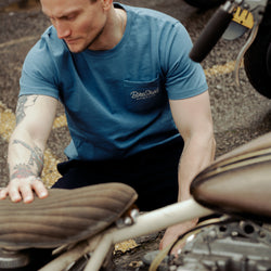 Steve inspecting a chopper wearing our Bike Shed Motorcycle Co. Embroidered Pocket T Shirt - Blue