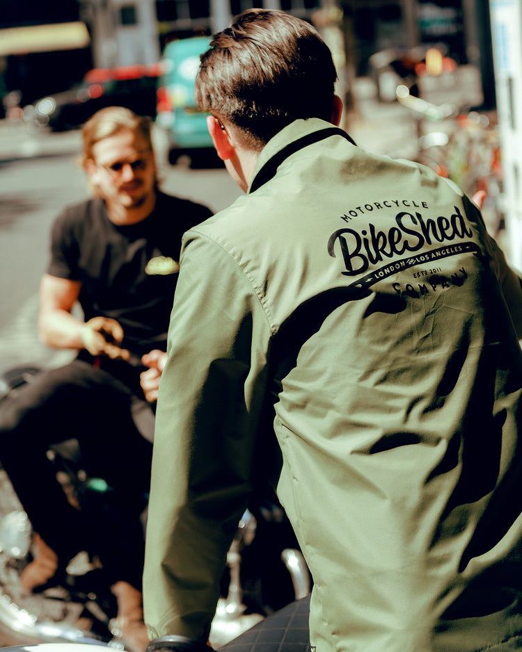 Joe chatting to Harry while wearing our BSMC Company Coach Jacket - Khaki Green