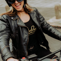 Model riding her bike wearing our Women's Motorcycle Garage Ribbed Tank Top - Black under her jacket