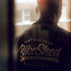 Model wearing our BSMC Company Coach Motorcycle Jacket - Black in artistic lighting