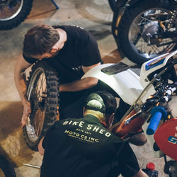 Gareth and Dan working on their bikes while wearing our Motorcycle BSMC ESTD. Pocket T Shirt - Black & Gold