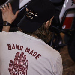 Gareth inspecting his bike while wearing our Bike Shed Motorcycle Company Graphic Handmade T Shirt - Cream