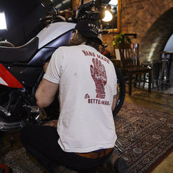Gareth working on his bike while wearing our Bike Shed Motorcycle Company Graphic Handmade T Shirt - Cream, back