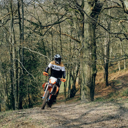 Dan riding in the forest wearing our BSMC Wing Race Jersey - Gold