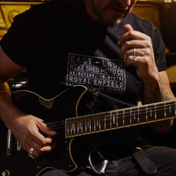 Donny playing guitar wearing our BSMC x Royal Enfield Vinplate T Shirt - Black