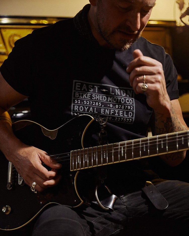 Donny playing guitar wearing our BSMC x Royal Enfield Vinplate T Shirt - Black