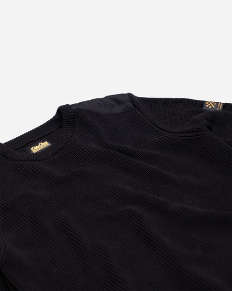 A black knit crew neck sweater with the Bike Shed Moto Co. brand label visible on the lower left side.