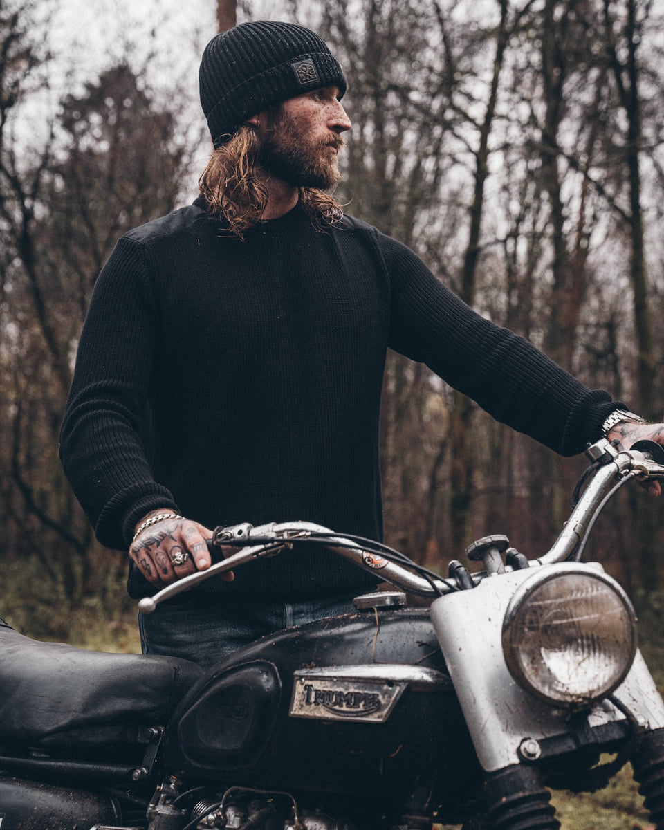 A black knit crew neck sweater with the Bike Shed Moto Co. brand label visible on the lower left side.
