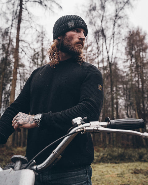 A black knit crew neck sweater with the Bike Shed Moto Co. brand label visible on the lower left side.