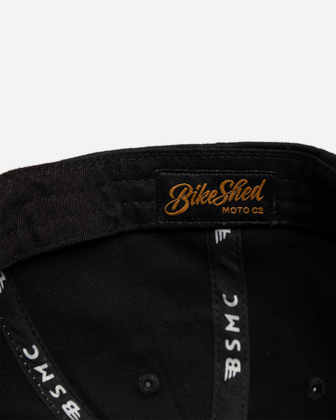 Black and beige Baseball Hat with Bike Shed Moto Co. logo on a white background inside detail