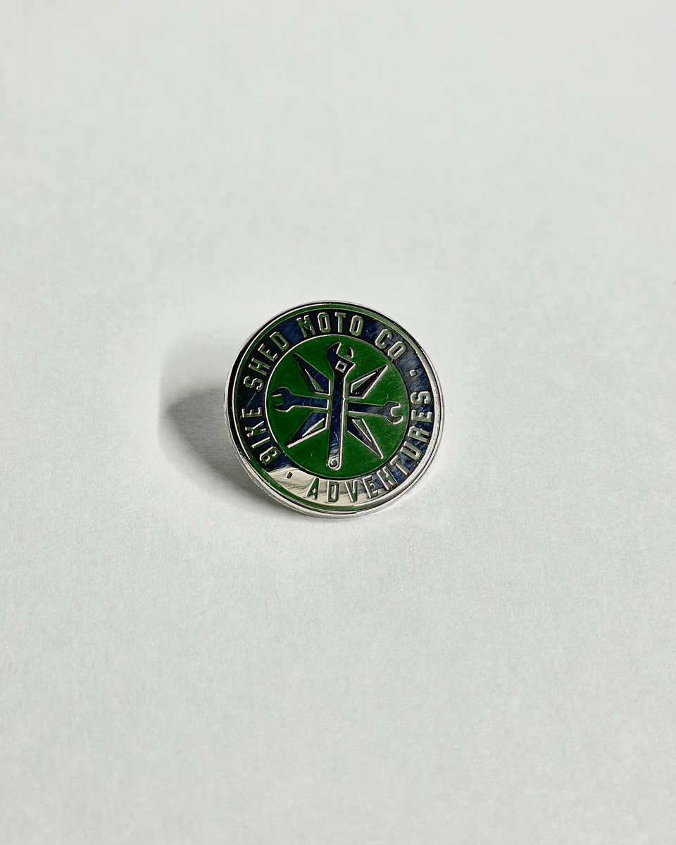 Green and silver enameled Bike Shed Moto Co Logo Adventures Pin