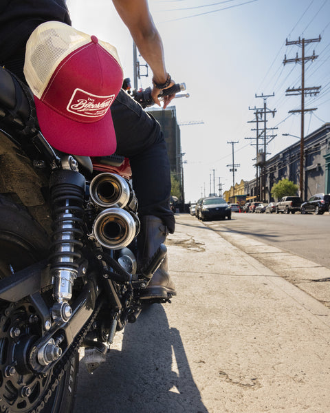 BSMC Inc. Cap - Burgundy & Cream, hanging from a belt loop