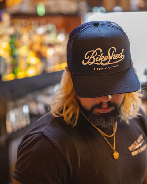 Bar staff member wearing our BSMC Motorcycle Garage Baseball Hat - Navy/White
