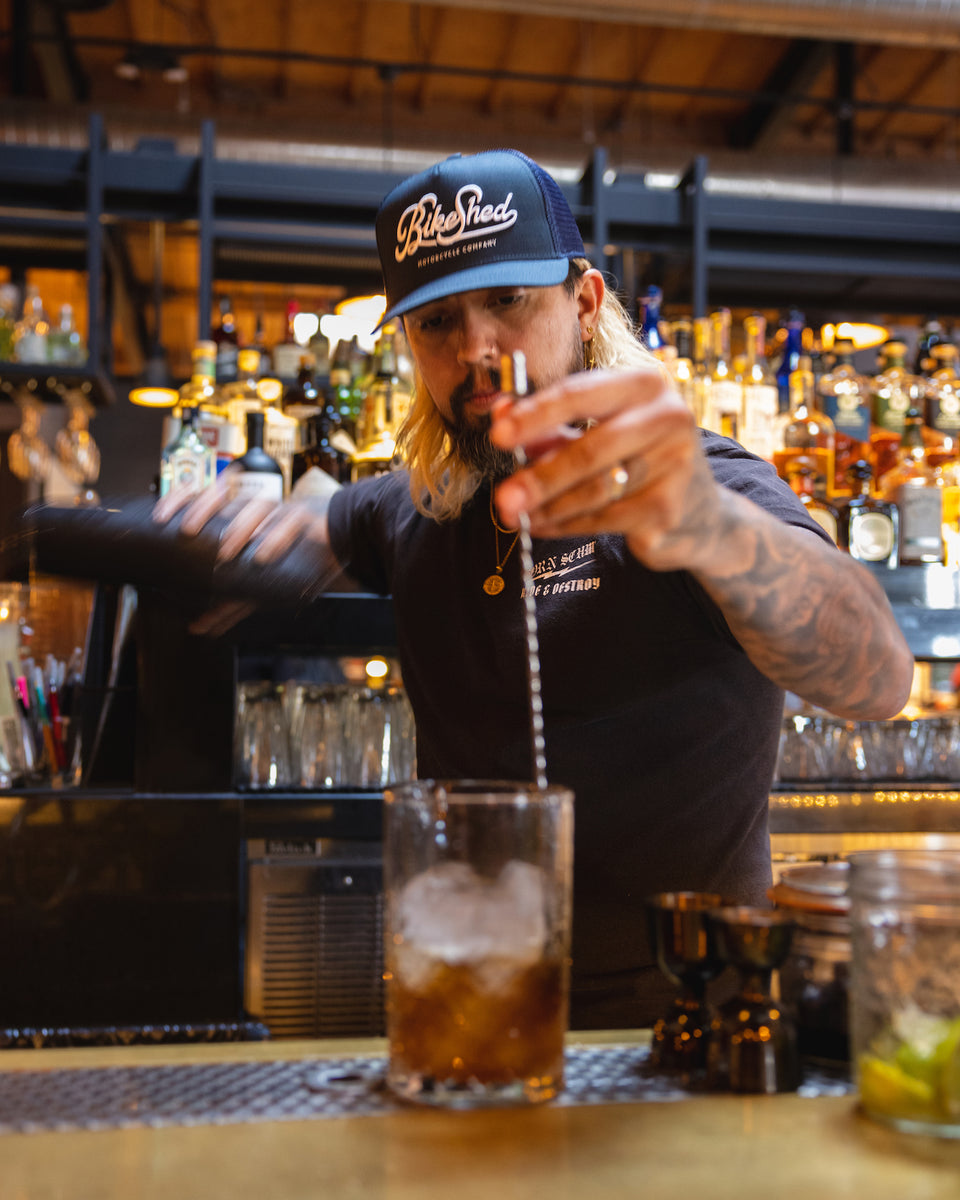 Bar staff wearing our BSMC Motorcycle Garage Baseball Hat - Navy/White