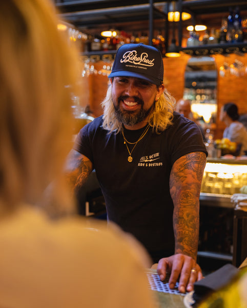 Bar staff member wearing BSMC Motorcycle Garage Baseball Hat - Navy/White