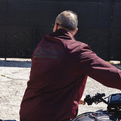 Dan sitting on his Indian bike while wearing our BSMC Company Coach Jacket - Burgundy 