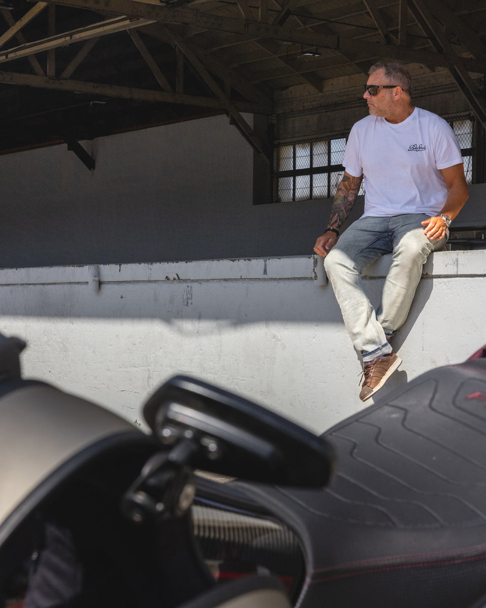 Dan sitting in the shade while wearing our BSMC Motorcycle Garage T Shirt - White & Black