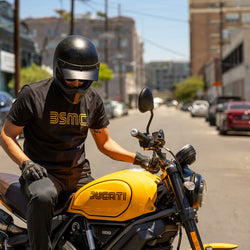 Model wearing BSMC '77 T shirt sitting on a Ducati Scrambler