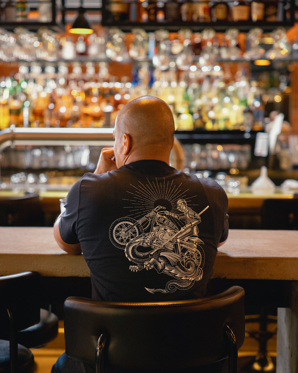 Bike Shed patron sitting at the bar wearing our BSMC Dragon Slayer Motorcycle T-Shirt - Black
