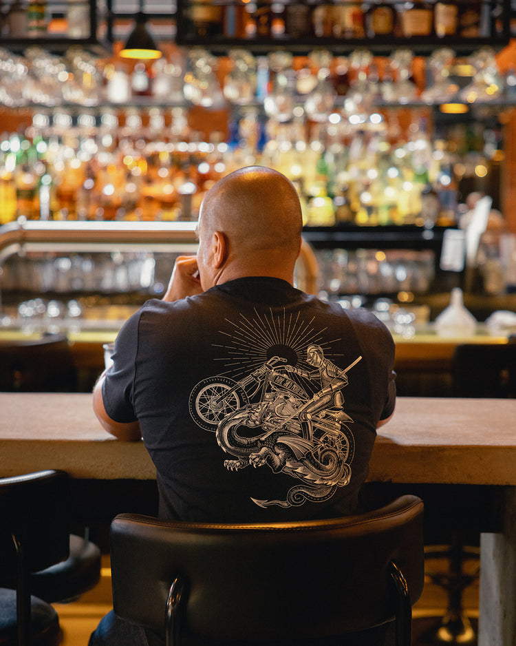 Bike Shed patron sitting at the bar wearing our BSMC Dragon Slayer T Shirt - Black
