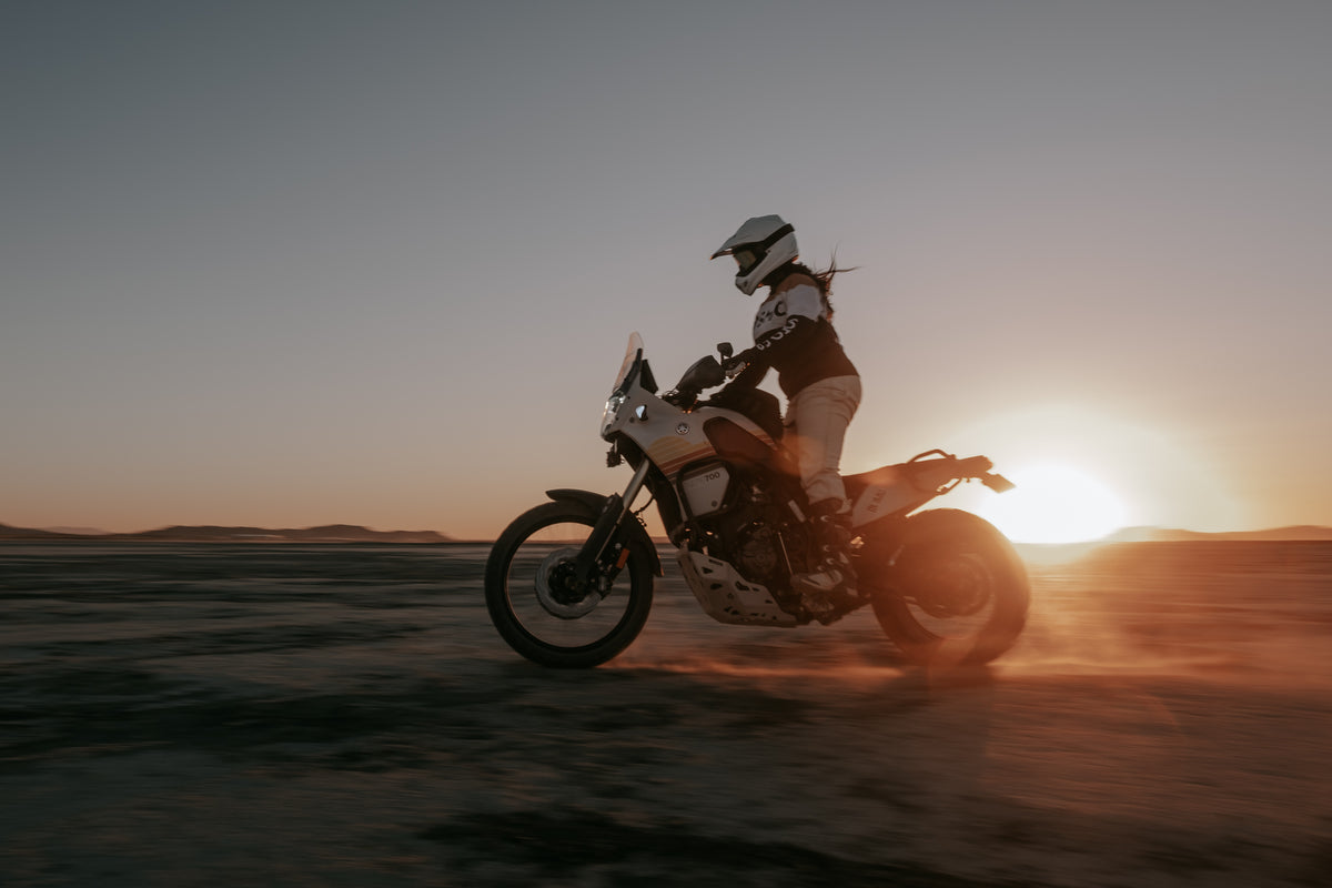Caro riding her Tenere in the sunset wearing our Motorcycle Wing Race Jersey - Gold