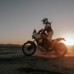 Caro riding her Tenere in the sunset wearing our BSMC Wing Race Jersey - Gold