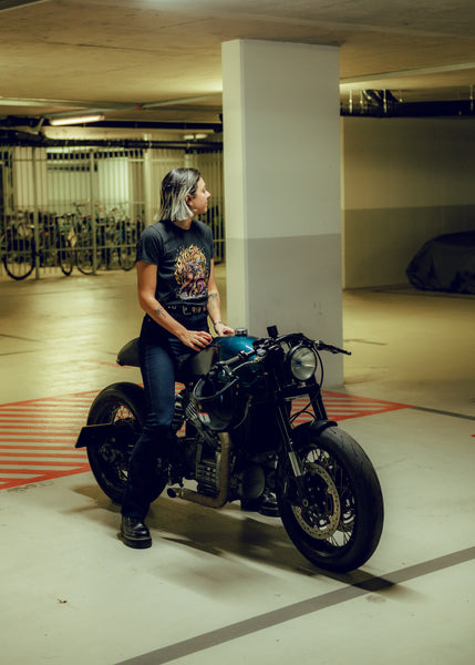 Model sitting on Honda CX500 wearing our BSMC Women's Speed Demon Graphic T-Shirt - Washed Black
