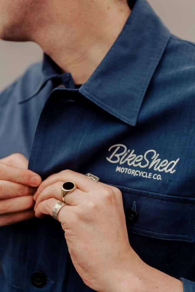 Joe buttoning up our BSMC Chain Stitch Chore Jacket - Blue