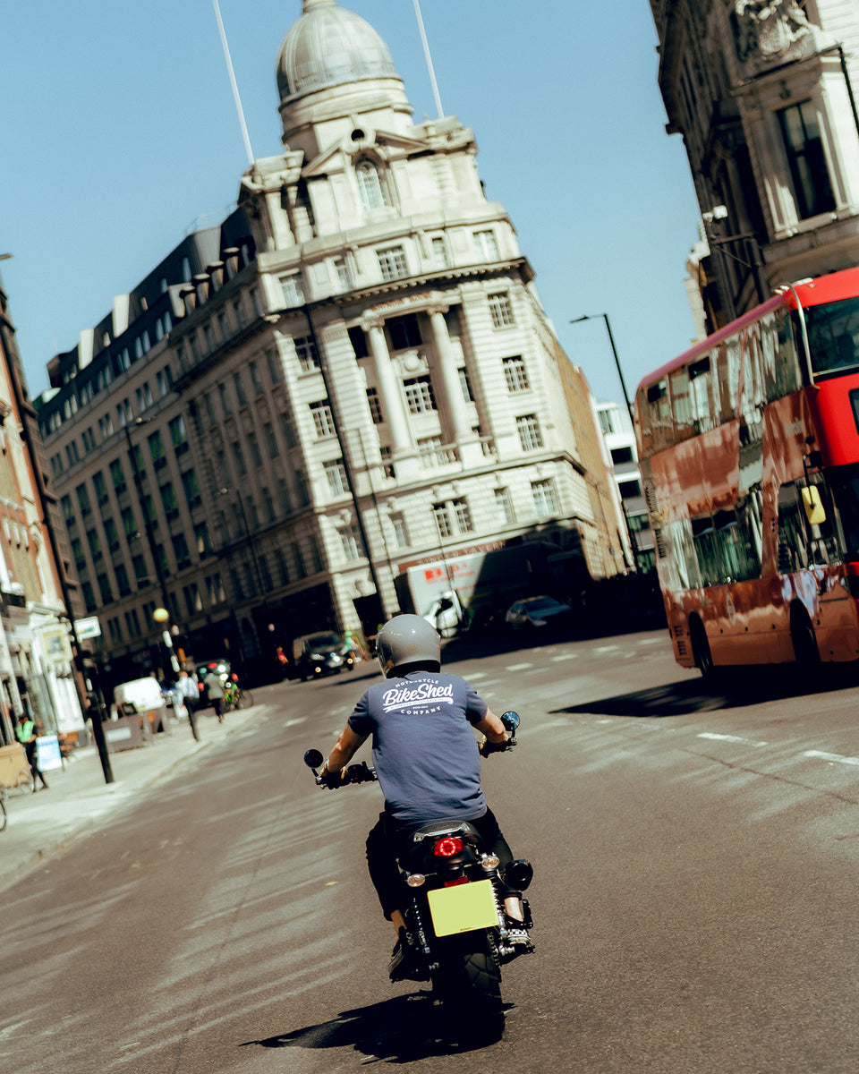Steve riding past a London bus while wearing our BSMC Company Logo T-Shirt - Navy