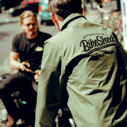 Joe chatting to Harry while wearing our BSMC Company Coach Jacket - Khaki Green
