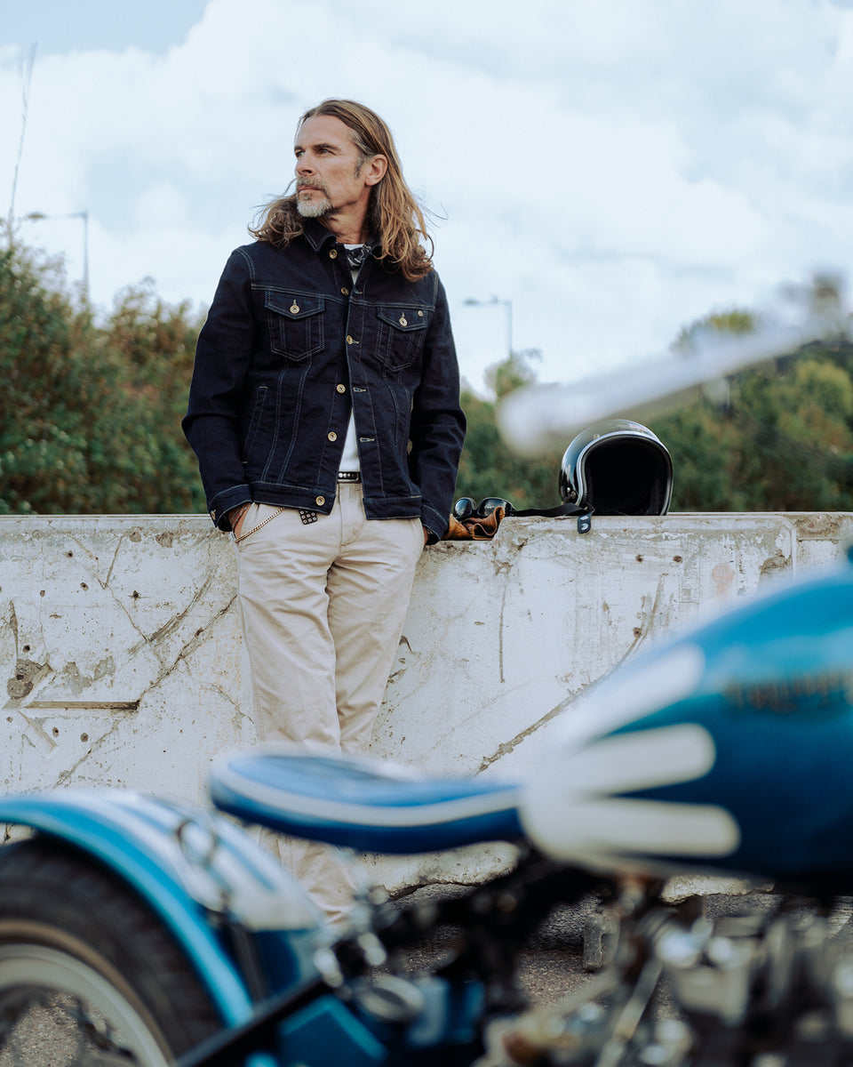 John standing near his Triumph wearing our BSMC Denim Jacket - Resistant Indigo