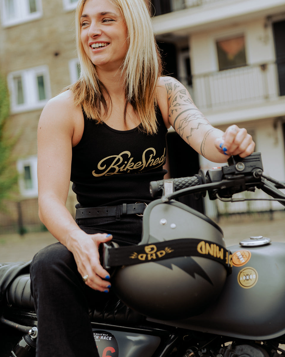 Model sitting on her bike wearing our Women's Motorcycle Garage Ribbed Tank Top - Black