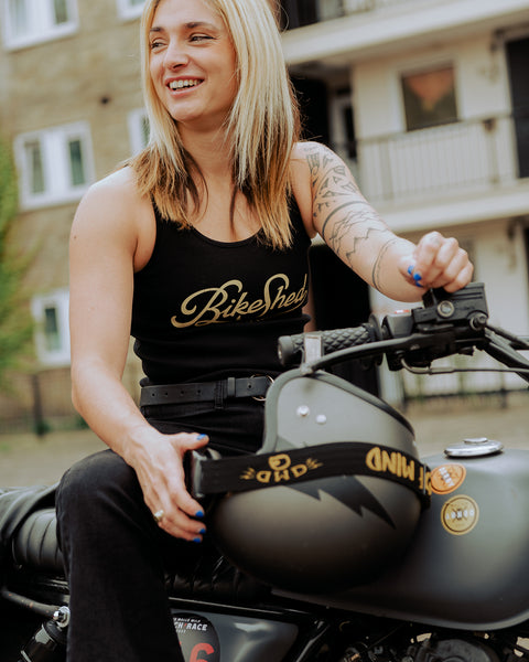 Model sitting on her bike wearing our Women's Motorcycle Garage Ribbed Tank Top - Black