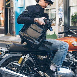 Kane stowing his camera in our BSMC x Royal Enfield Messenger Bag