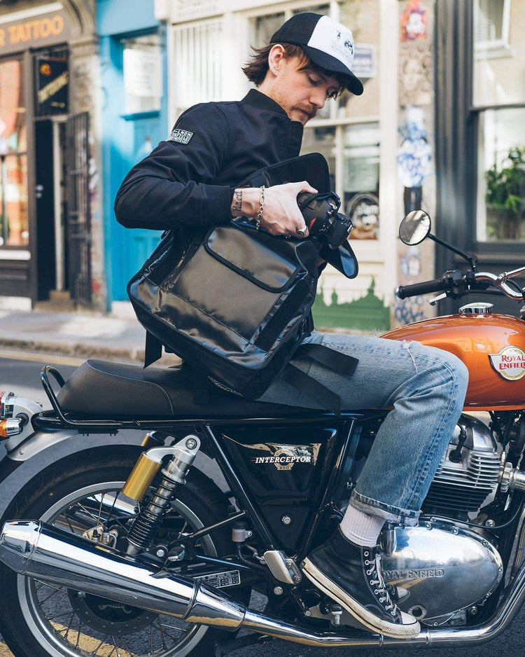 Kane stowing his camera in our BSMC x Royal Enfield Messenger Bag