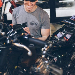 Harry wearing our BSMC ESTD. Cap - Black while working on his bike