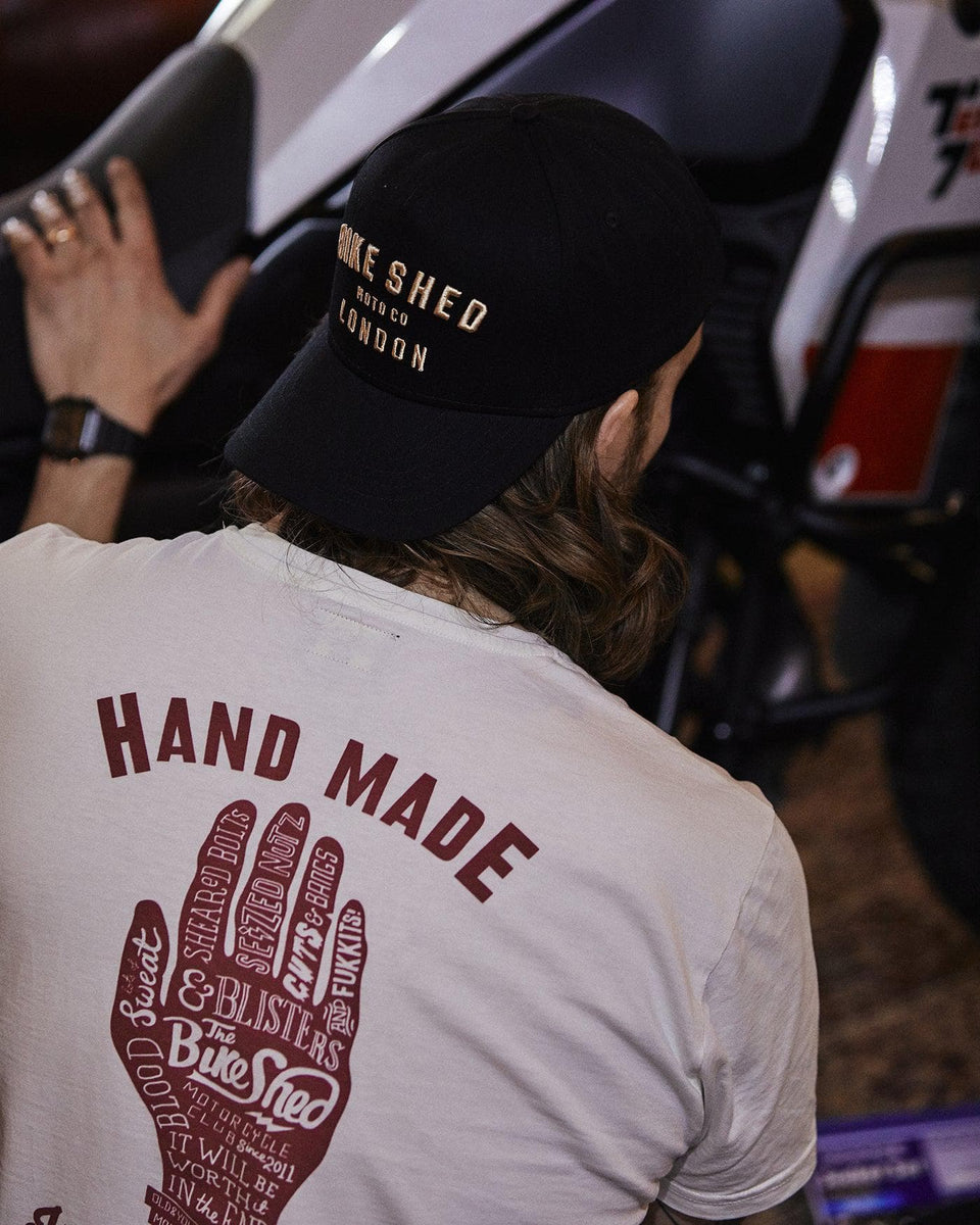 Gareth inspecting his bike while wearing our Bike Shed Motorcycle Company Graphic Handmade T Shirt - Cream