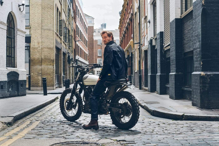 Model sitting on his bike wearing our BSMC Protective - Road Jean - Raw Indigo