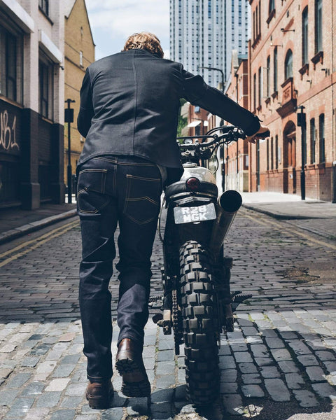 Model pushing his bike wearing our Protective Motorcycle Road Jeans - Raw Indigo