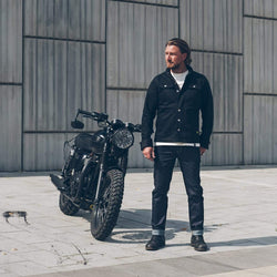 Donny, wearing our BSMC Resistant - BSR01 Jean - Raw Indigo standing next to his Triumph