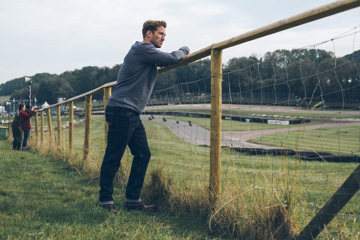 Model by a racetrack wearing our Motorcycle Resistant - BSR01 Jeans - Raw Indigo